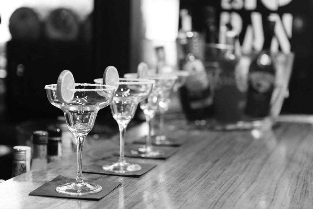 black and white image of drinking glasses at bar with bar insurance